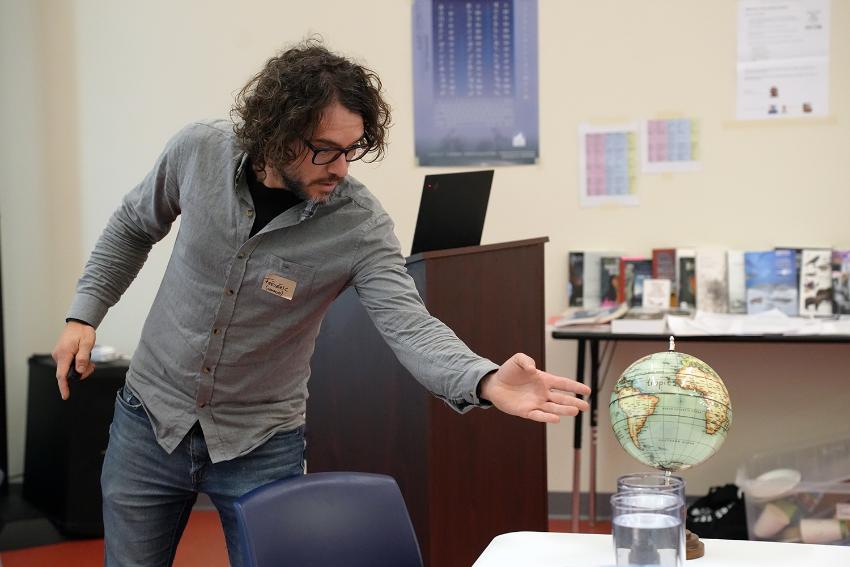 En mann peker på en jordklode