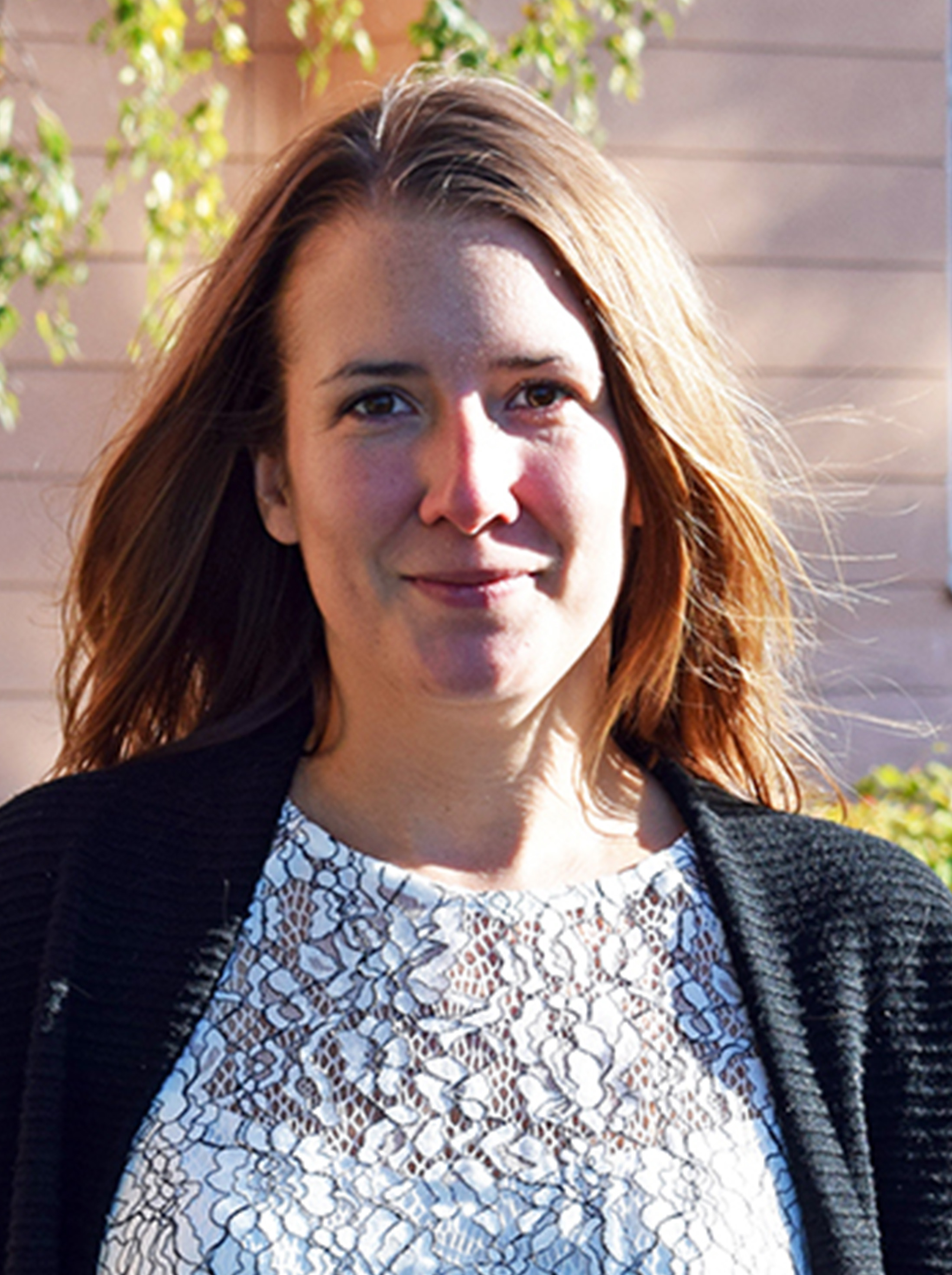 En kvinne ser mot kameraet og smiler