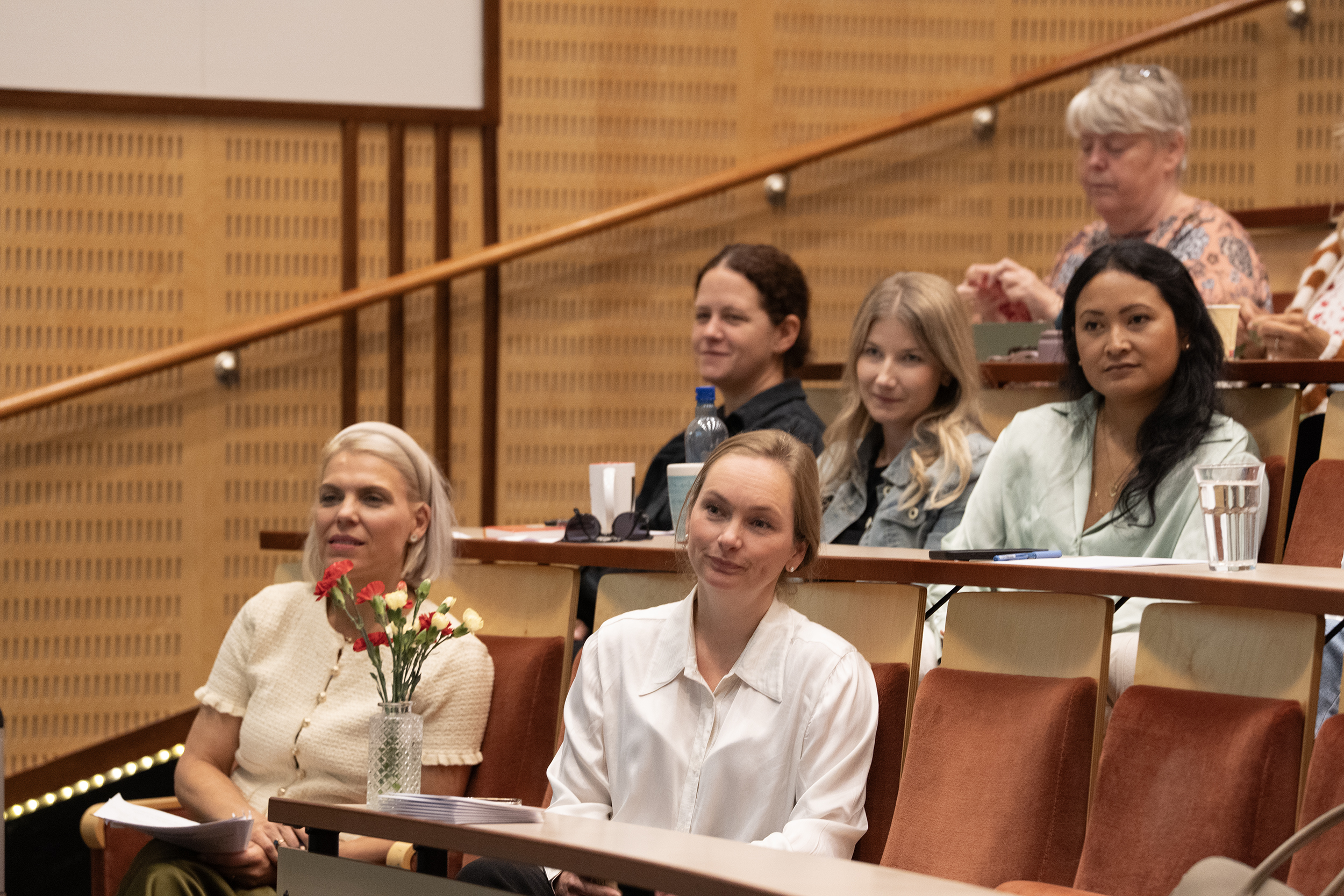 Personer sitter og lytter til et foredrag. 