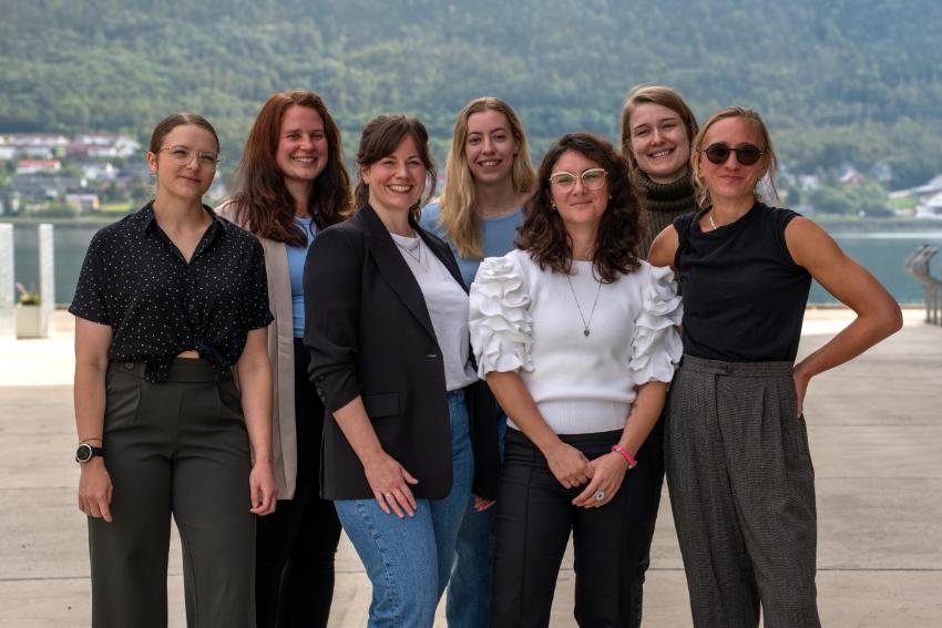 Gruppebilde av syv damer som står ute og smiler til fotografen.