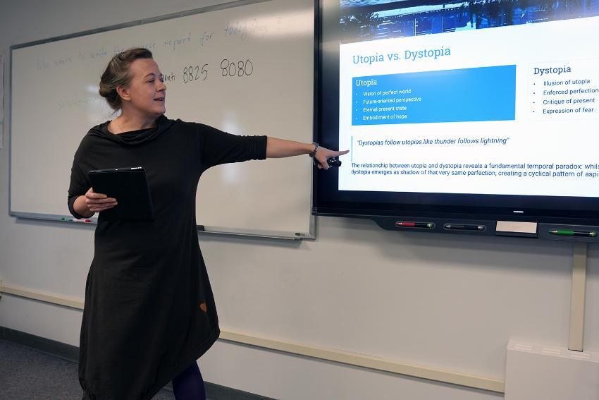 Person står foran en presentasjon og snakker