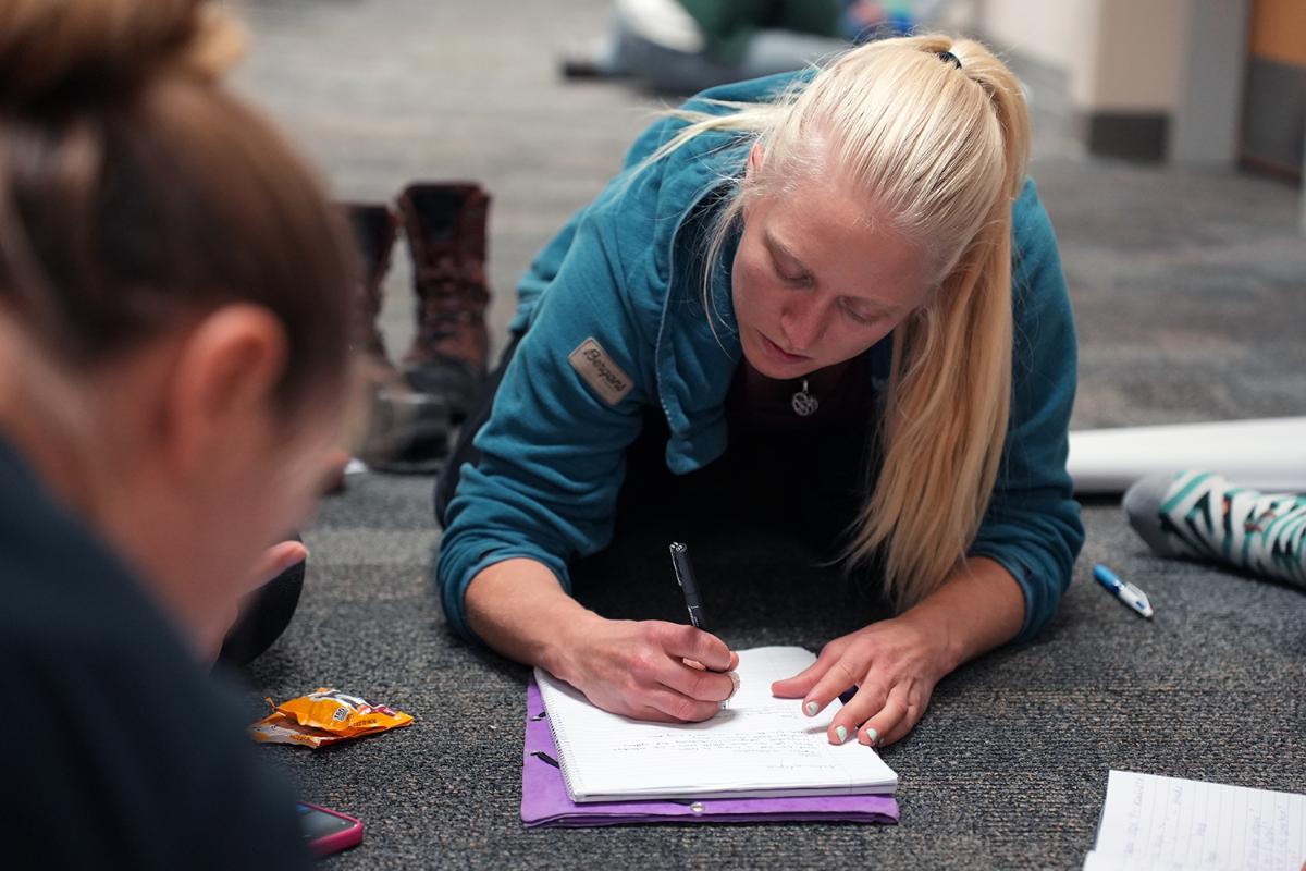 Evelina.jpg En ung kvinne skriver på et papir