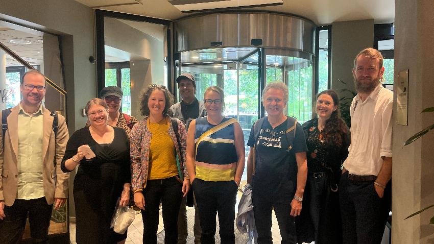 Personer samlet og smiler tilkamera