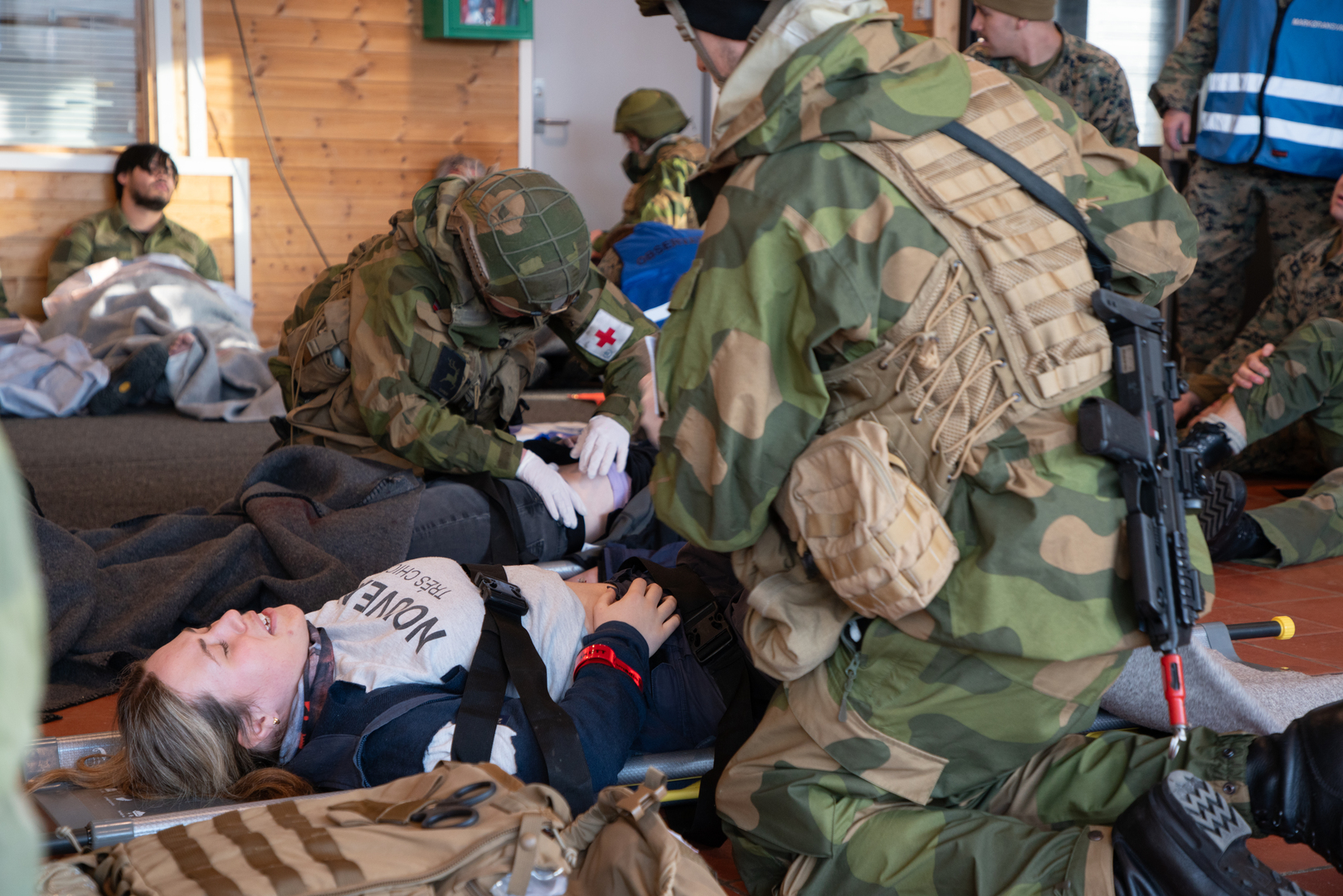 Evakueringsovelse_UIT_24013_Foto_Jorn_Berger_Nyvoll.jpg folk med kamuflasje som hjelper en person på båre