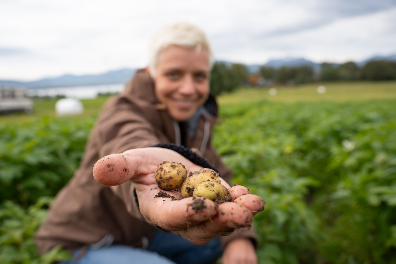 dame som holder poteter i en utstrakt hånd