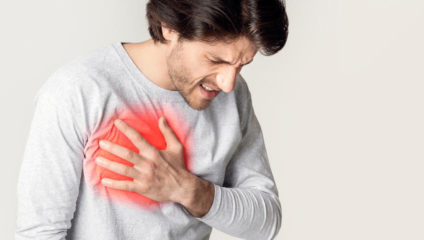 Mann holder seg til hjertet