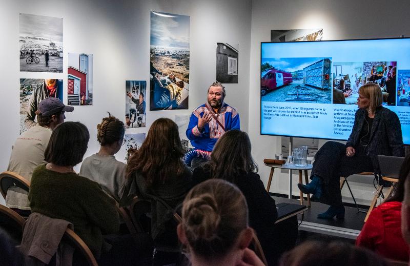 to mennesker på den scene som snakker sammen. den ene har samisk kofte.