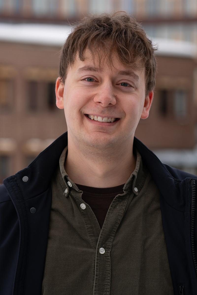 En mann ser mot kameraet og smiler