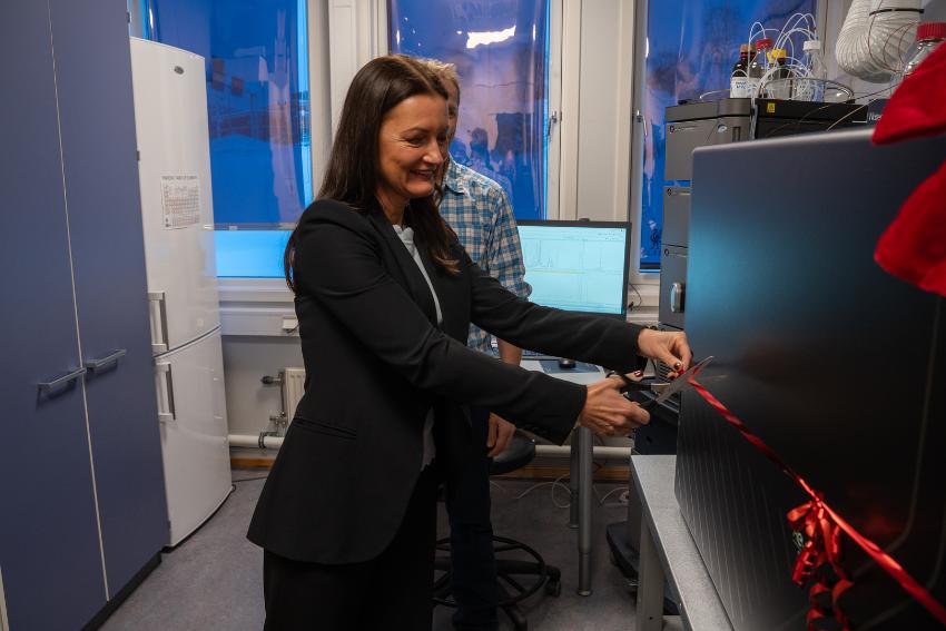 Kvinner klipper over en snor på et laboriatorium.