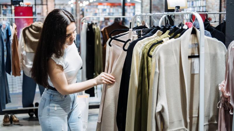 Dame som ser på klær i en butikk
