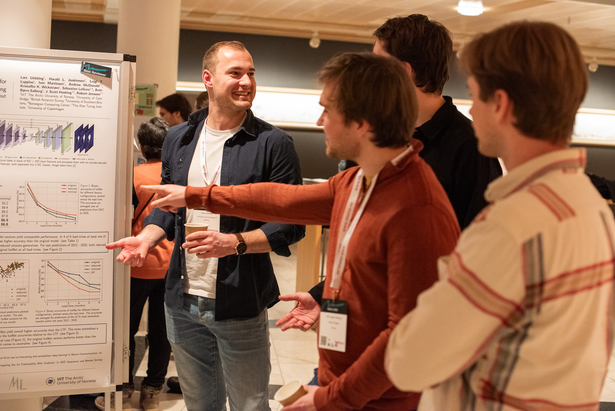 En mann viser fram forskningen sin til mange personer