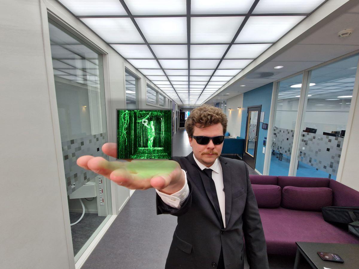 En mann holder en liten skjerm i hånden