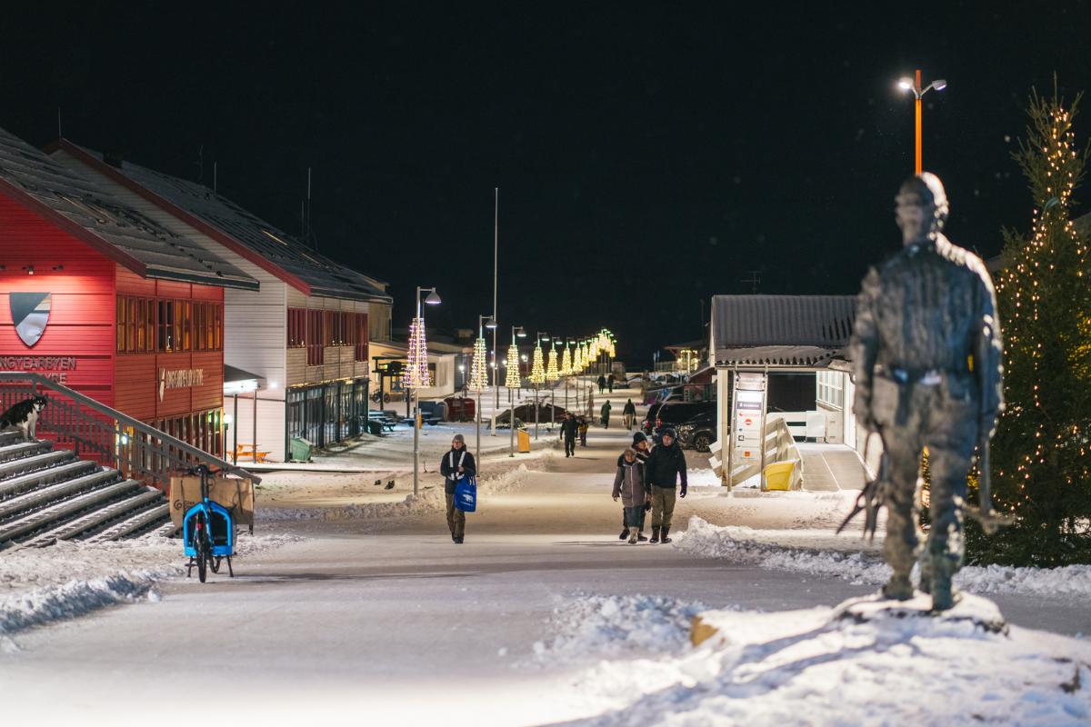 Sn&oslash;dekt g&aring;gate med vinterkledde mennesker som g&aring;r