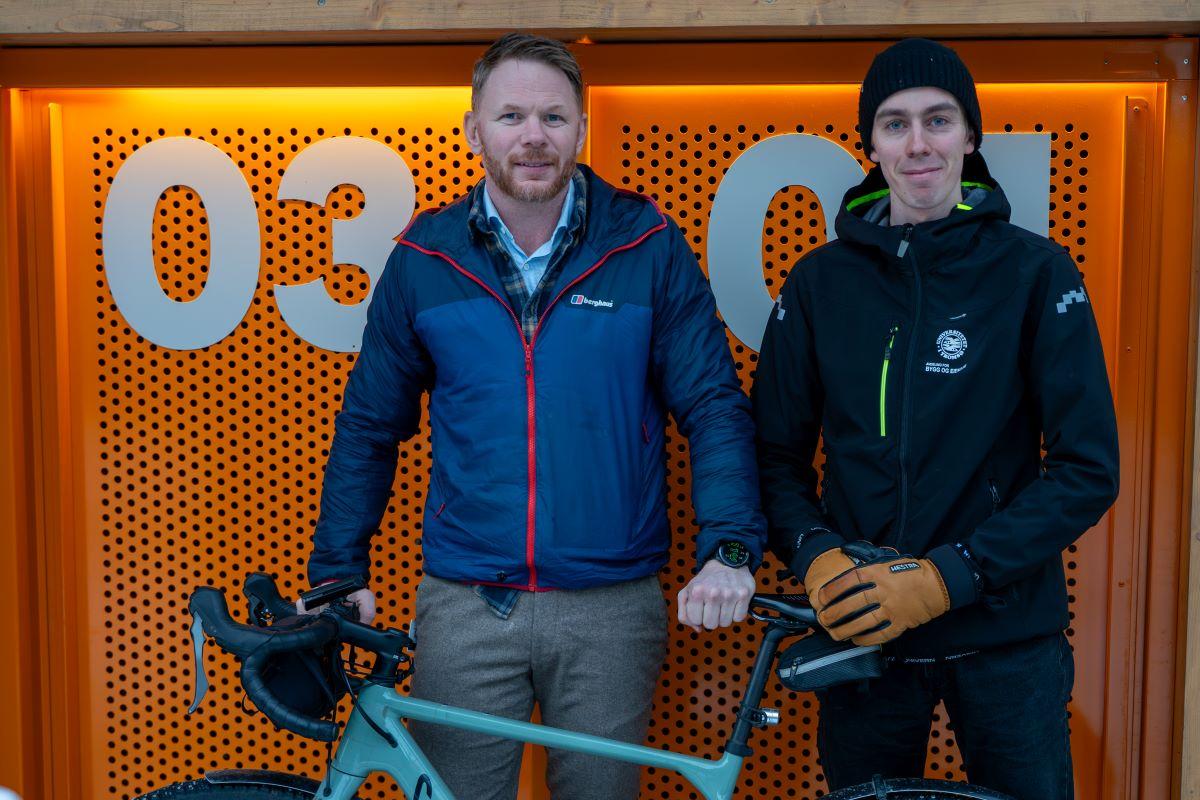 To menn foran et oransje skap med tall p&aring;