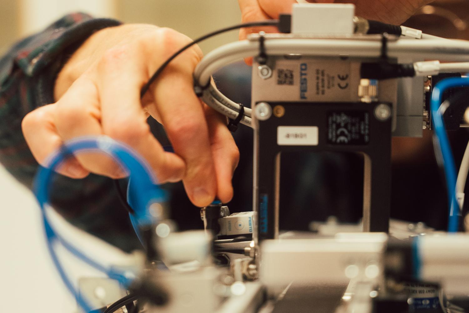 Student som bygger miniatyr av samleb&aring;nd og justerer p&aring; sm&aring; deler