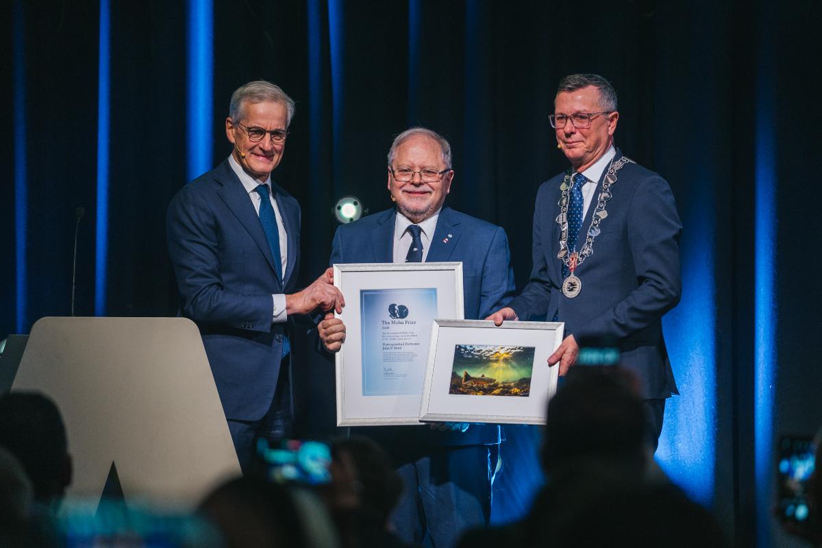 Tre glade menn p&aring; en scene med diplom