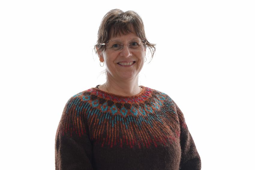 Portrettbilde av kvinne som ser i kamera og smiler. 