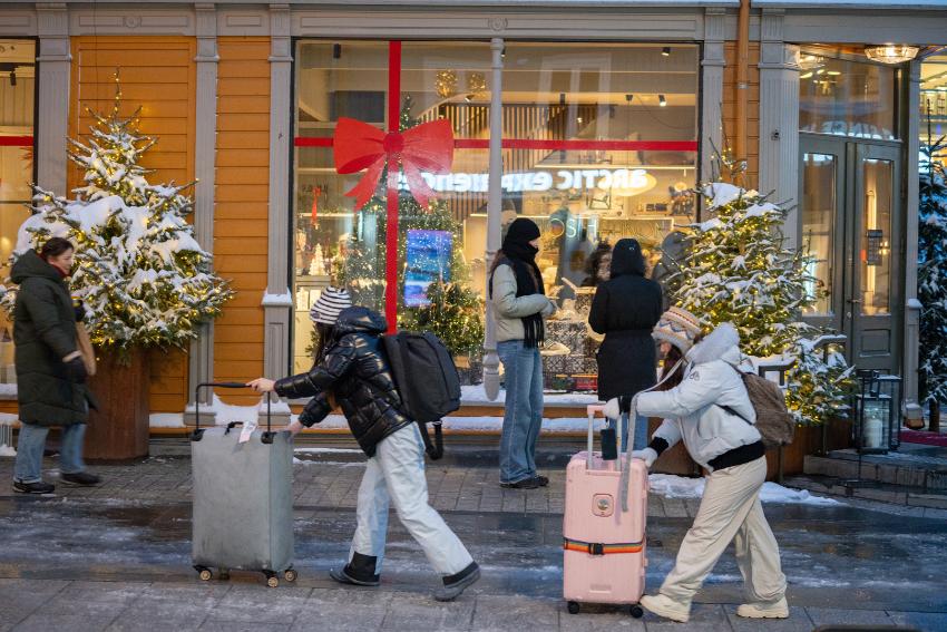 to asiatiske turister som triller kofferter i byen 