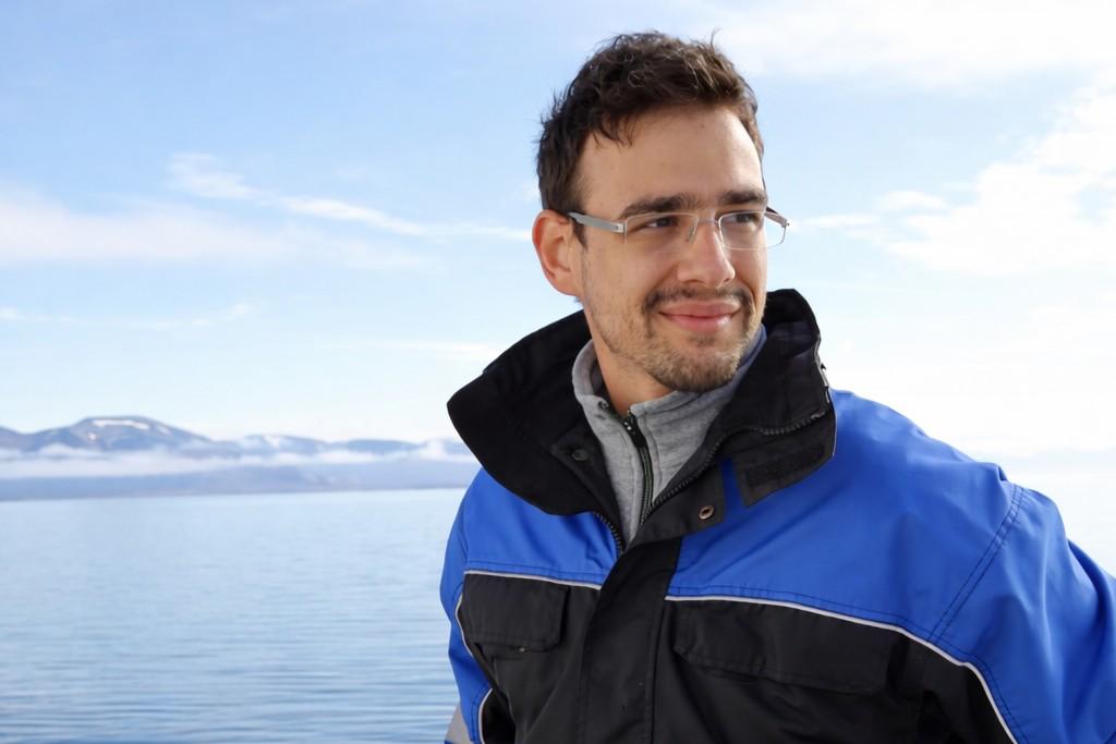 "A portrait picture of Nikolaos, he has a mustache and glasses, and he is smiling.