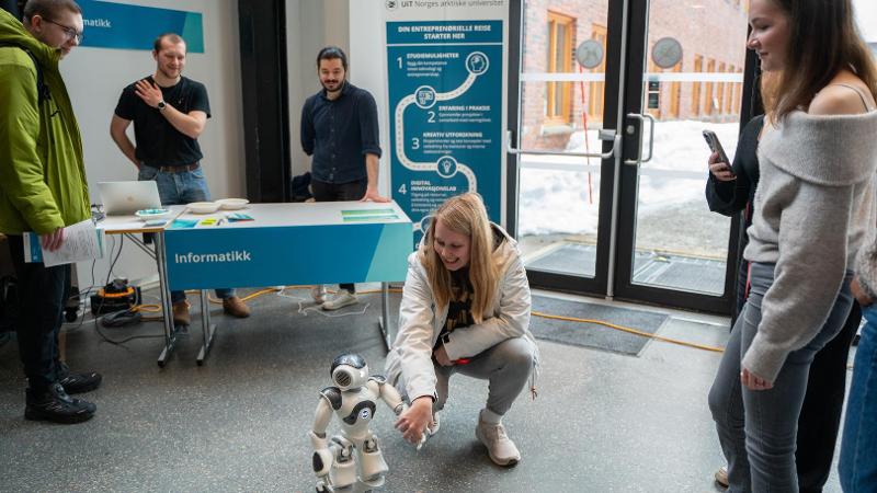 jente som hilser p&aring; en liten robot