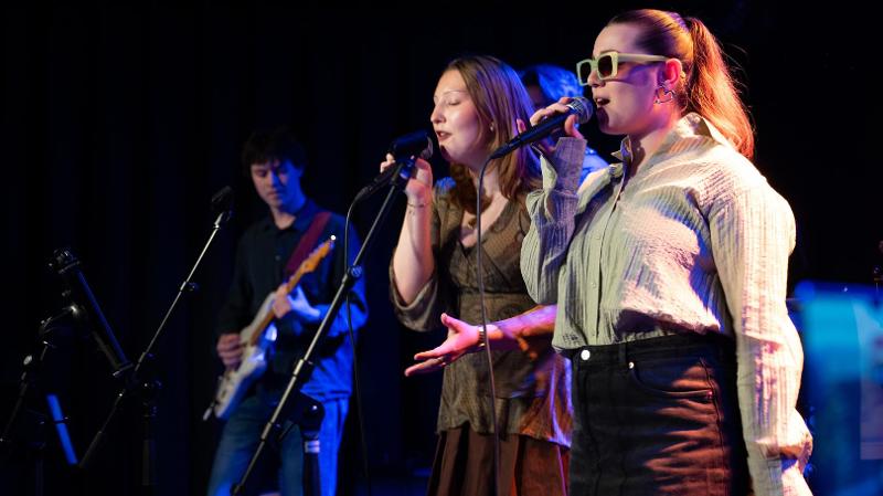 to damer som synger p&aring; en scene