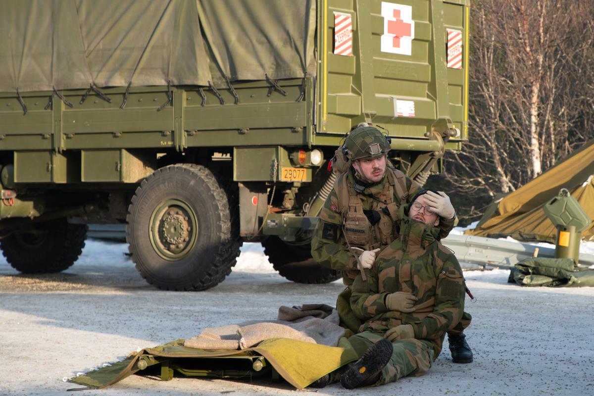 to menn i uniform som &oslash;ver p&aring; evakuering ute i det fri