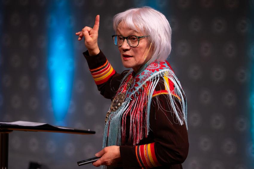 dame med samisk kofte som prater p&aring; en scene