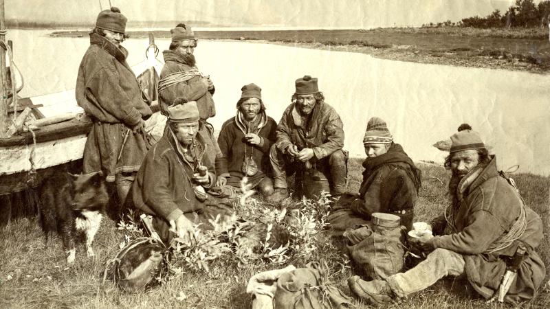 old photo in black and white of samis in a circle drinking coffee