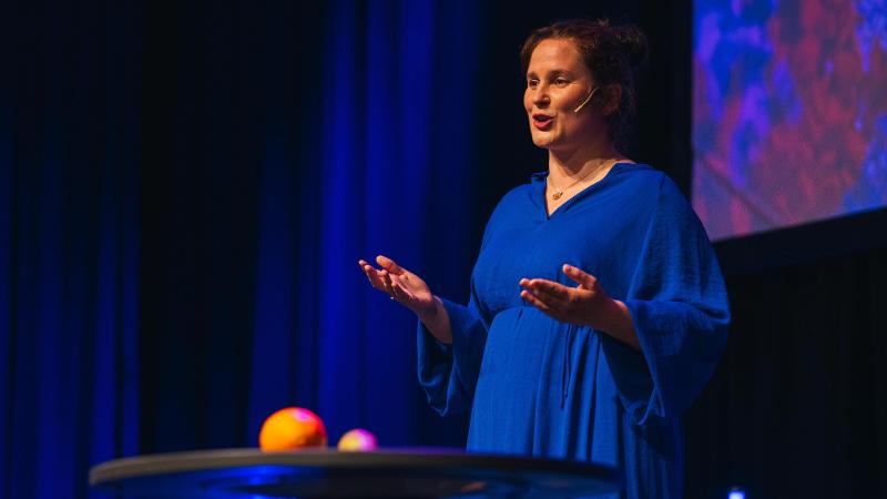 dame med bl&aring; kjole som st&aring;r p&aring; en scene