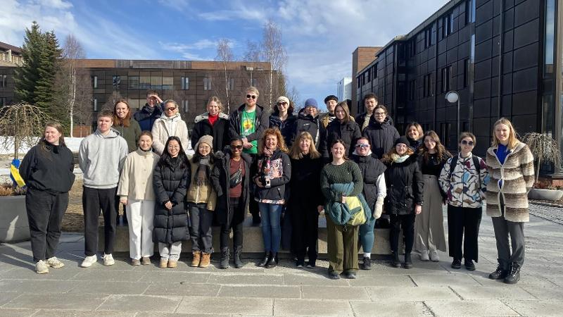 many people standing together outside in front of university buildings