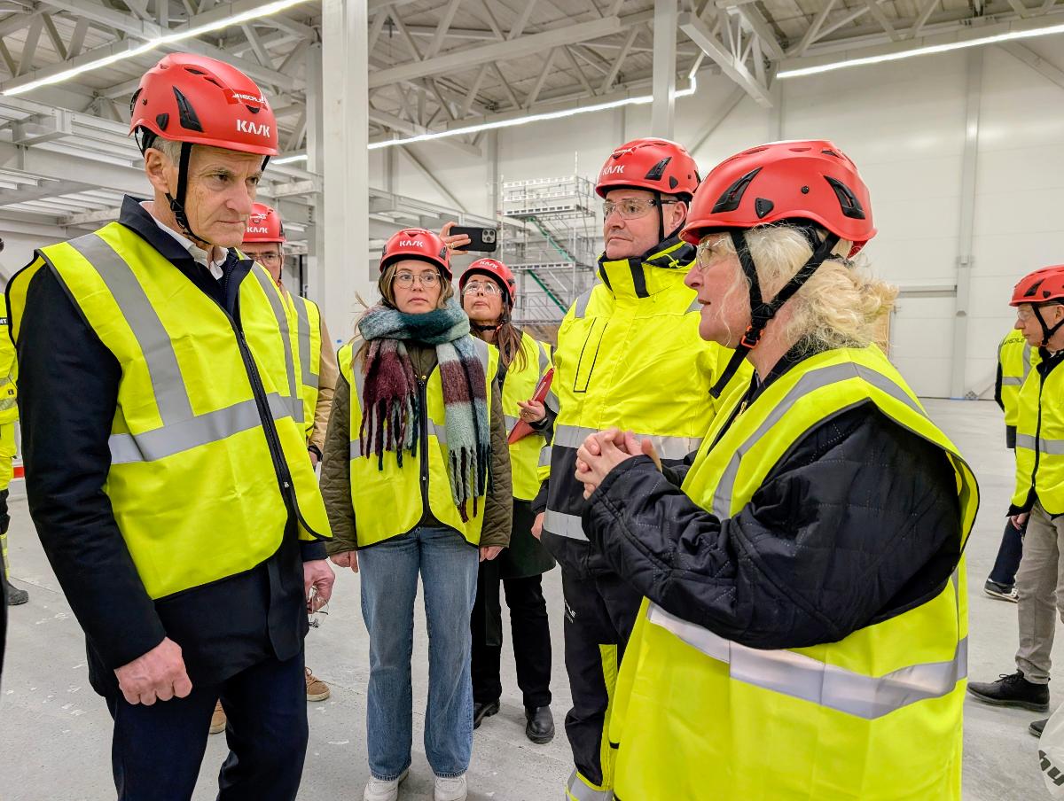 To personer snakker sammen i fabrikkhall. 