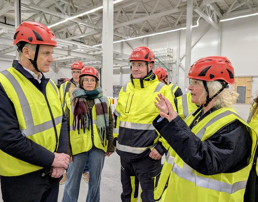 To personer snakker sammen i fabrikkhall. 