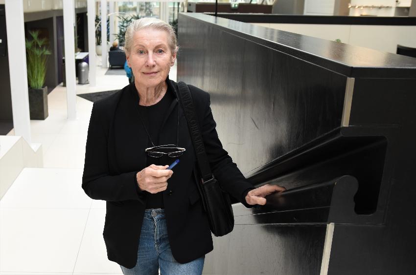 Kvinne går opp trapp og ser i kamera