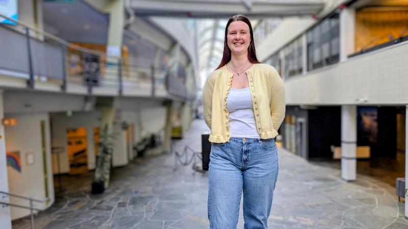 dame som st&aring;r inni universitetsbygg