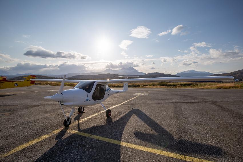 Lite elektrisk fly p&aring; flyplassen i Bardufoss, med sol og skyer i bakgrunn.