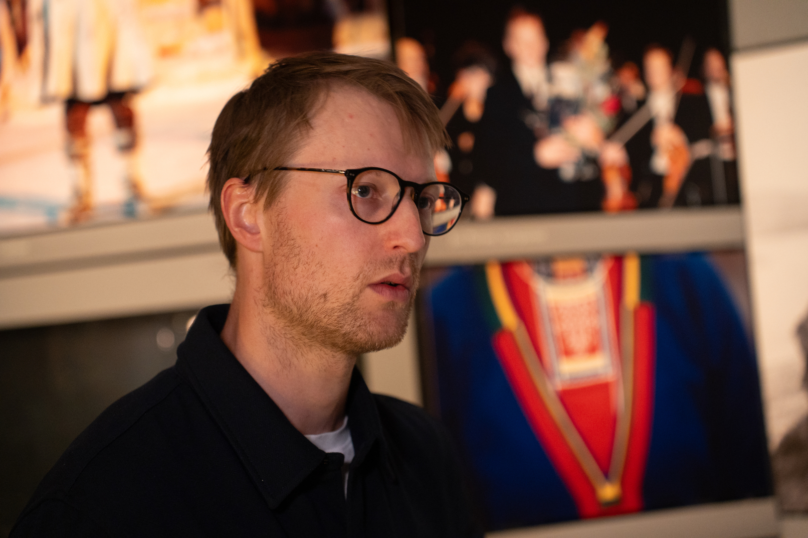 Sigurd Sælthun-05374.jpg Forsker foran bilder med samiske symboler.