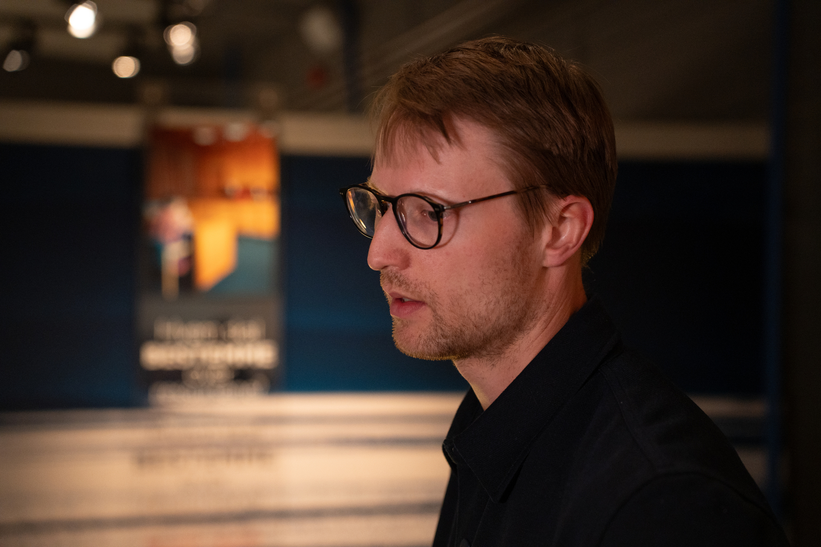 Forsker foran samiske symboler inne p&aring; et museum. 