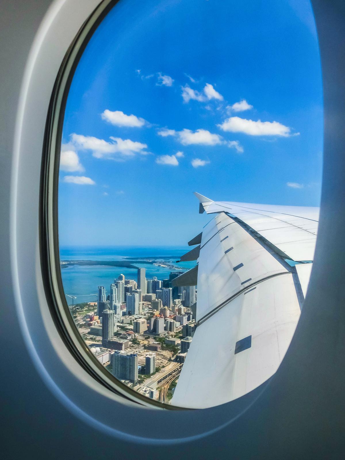 mp27843862-miami-beach-skyline-from-airplane-porthole.jpg flyvindu med en strand og storyby utenfor