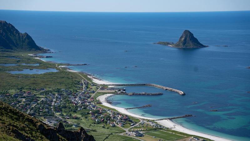 strand og hav og en bratt &oslash;y ute i havet