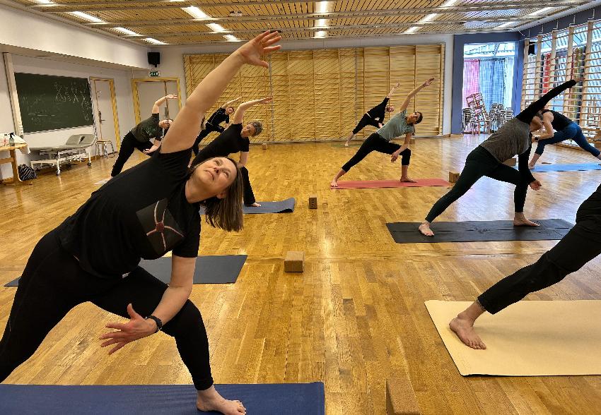 Smilende dame cirka seksti &aring;r som gj&oslash;r yoga p&aring; en gymmatte. 