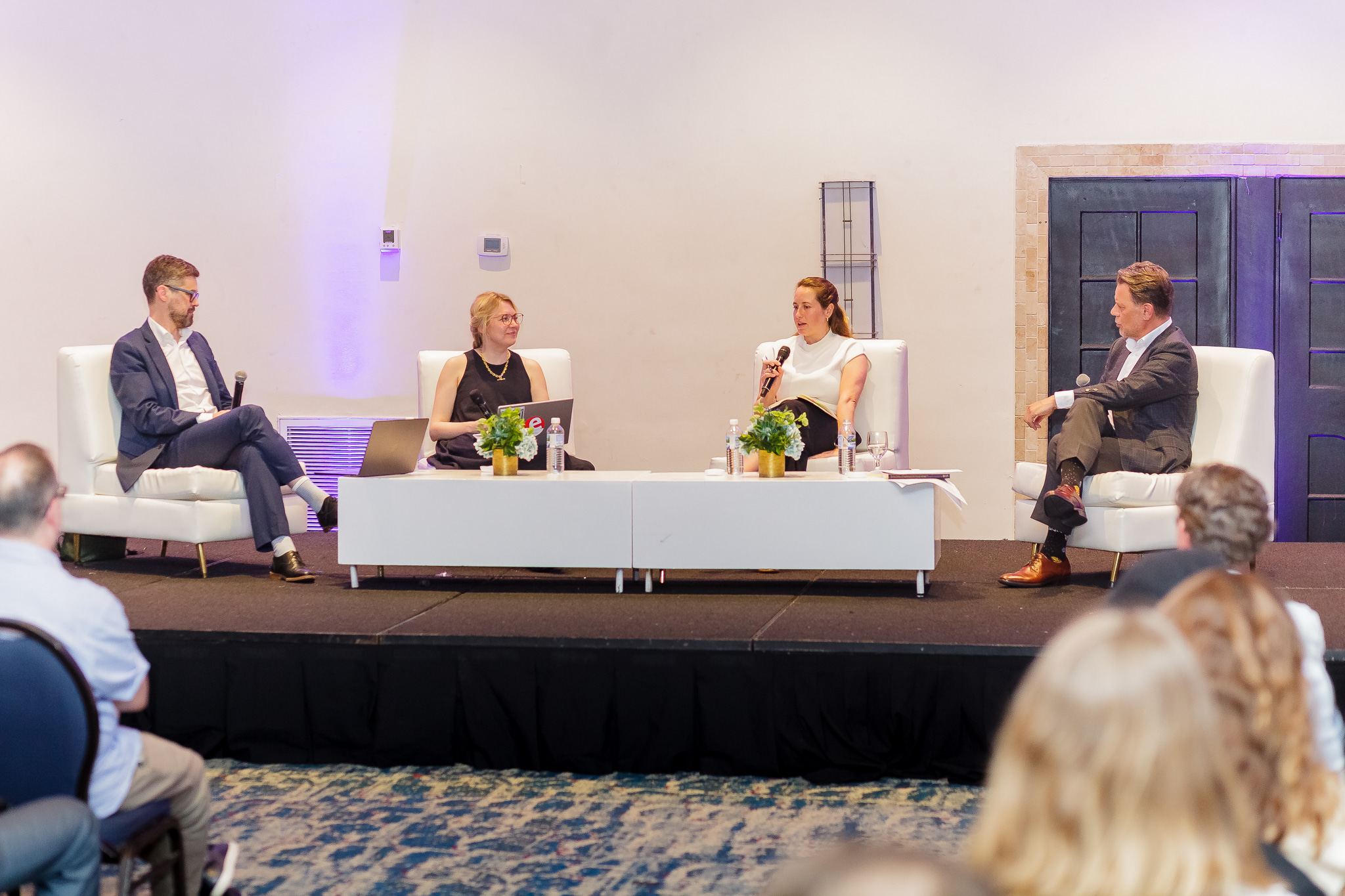 four people in white chairs in roundtable discussion