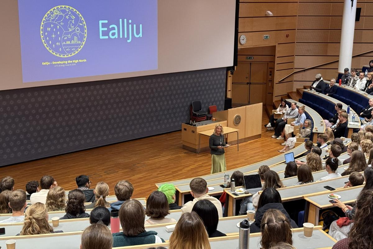 Studenter samlet i et audiotorium, mens de lytter til en taler.