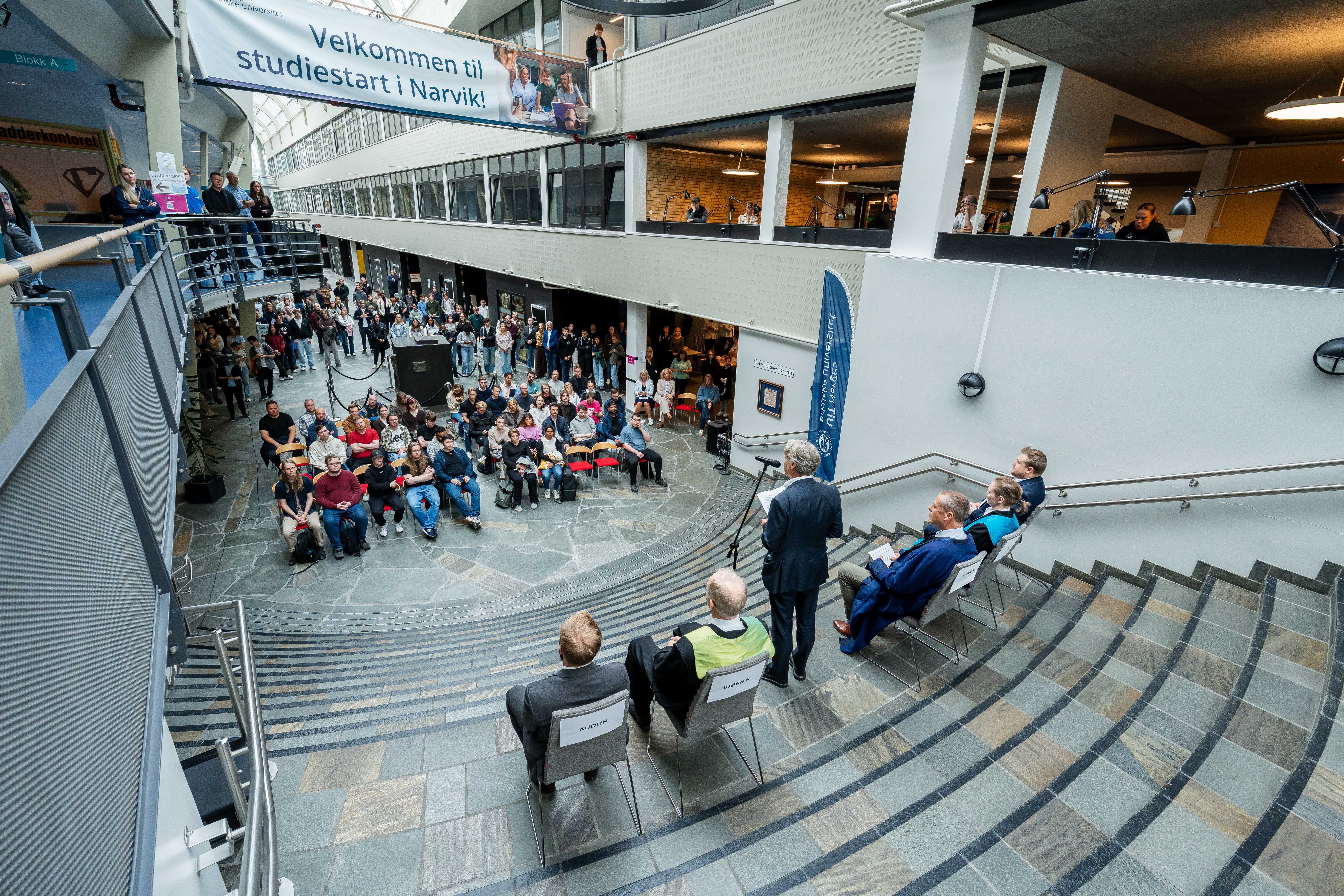 Eirik Frantzen - Nordkraft AS_1.jpg Mann taler til studentpublikum under studiestart inne i universitetsaula.