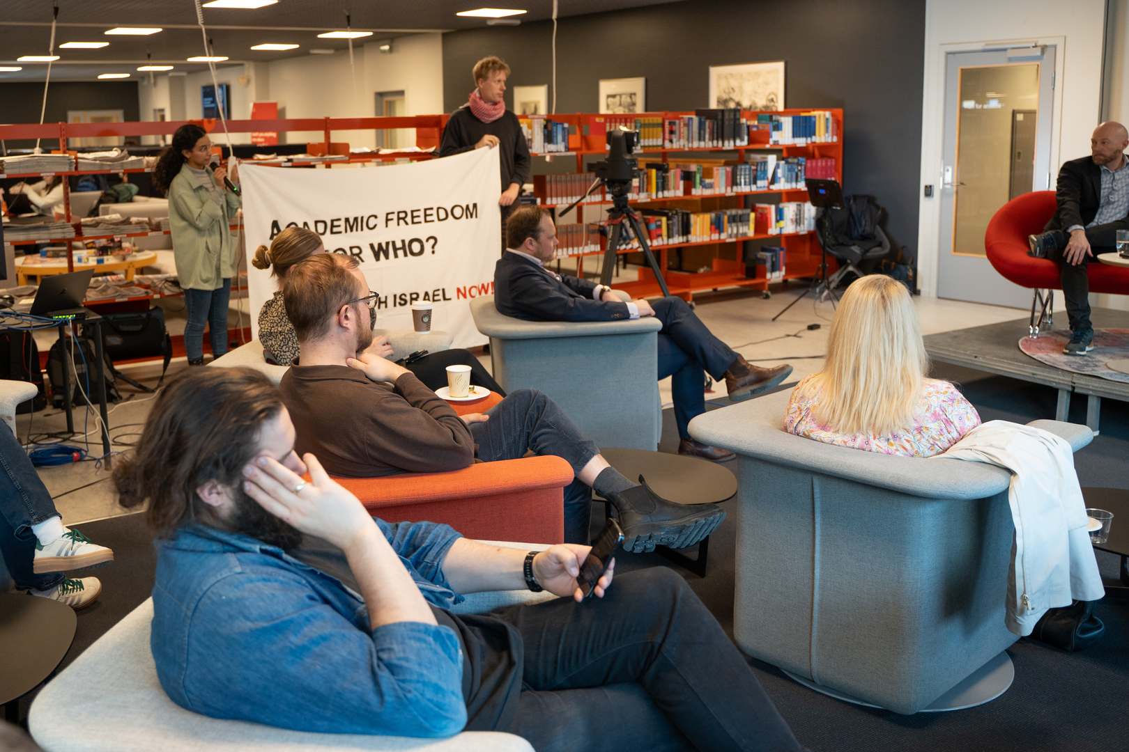 Akademisk ytringsfrihet er tema for UiT samtaler (2).jpg Folk i lenestoler på samtale-arrangement på et universitetsbibliotek.
