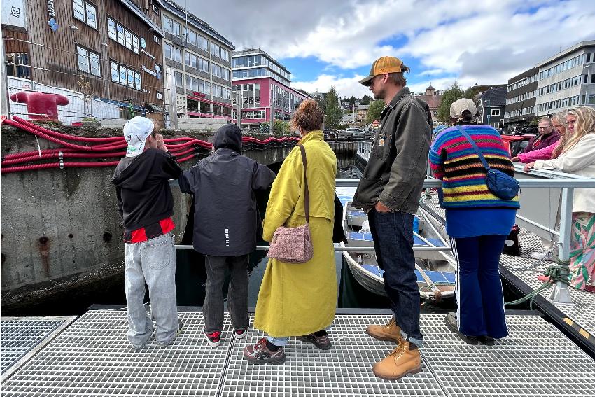 Personer som står ved en brygge.