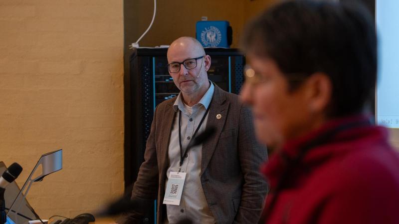 mann som st&aring;r ved en PC og lytter til en dame