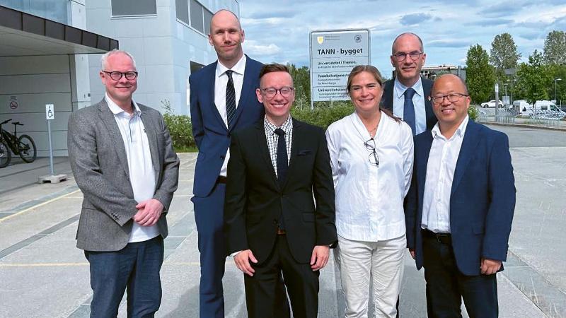 mennesker som st&aring;r samlet utenfor et bygg