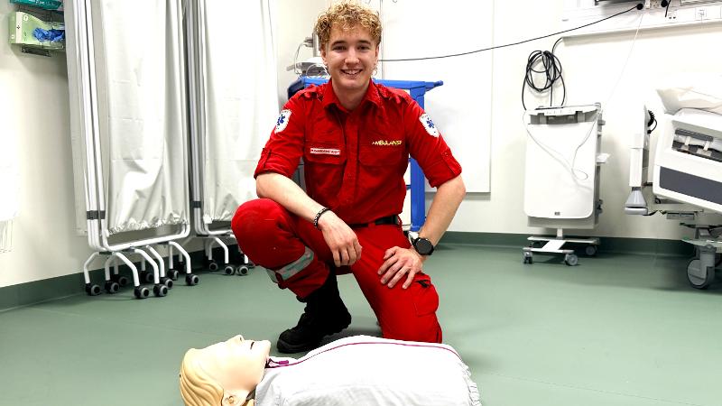 mann med paramedic uniform som sitter foran HLR-dukke
