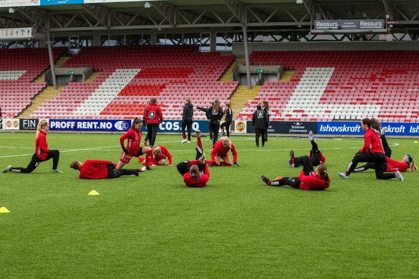 Fotballspillere som tøyer på gressmatta