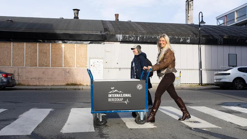 to kvinner g&aring;r over et fotgjengerfelt med en tralle